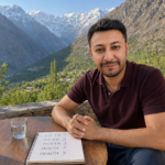 Shahbaz Ahmed founder of KetoFramework in a burgundy polo shirt sitting outdoors at his Gilgit-Baltistan morning table with a handwritten intermittent fasting results timeline notepad and a cup of black tea looking directly at camera with a warm confident smile representing intermittent fasting results and what to realistically expect week by week